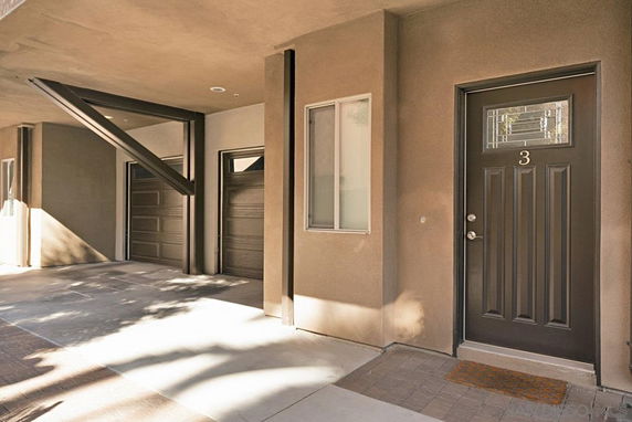 Front view of a building with a modern entrance and garage doors.