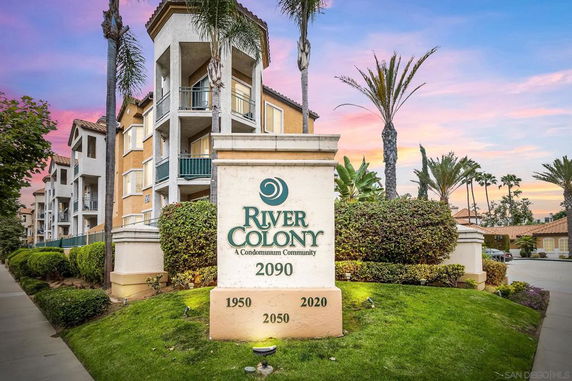 Front view of a condominium building with multiple floors and balconies.