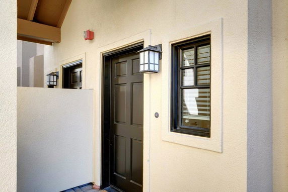 Front view of a house entrance with a black door and a window.