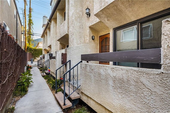 Front view of a multi-story townhouse with stucco exterior and balconies.