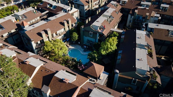 Aerial view of residential buildings surrounding a swimming pool.