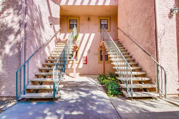 Front view of a stairway leading to entrances in an apartment building.