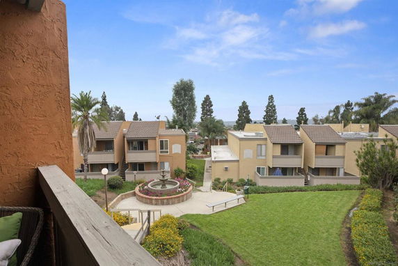 View of residential buildings with balconies and surrounding greenery from a higher vantage point.