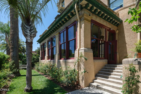 Side view of a historical building with large windows and decorative architectural features.