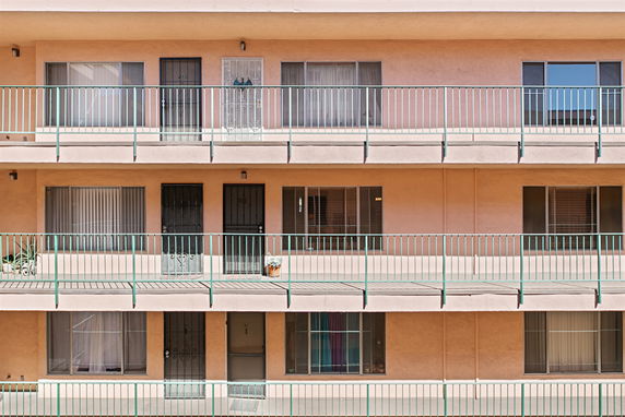 Front view of a multi-story building with balconies and windows.