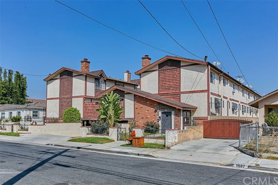 Front view of a multi-story residential building with brick and stucco exterior.