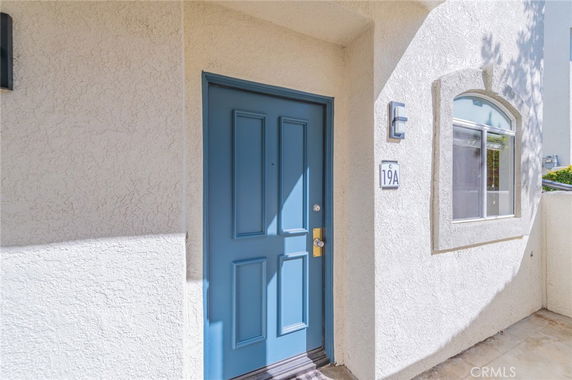 Front view of a building entrance with a blue door and adjacent window.