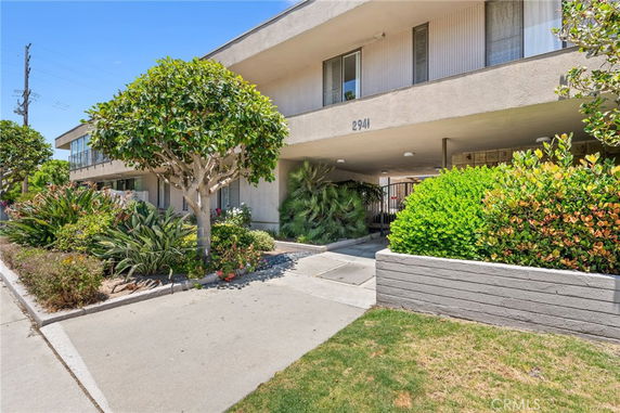 Front view of a two-story residential building with a landscaped garden.