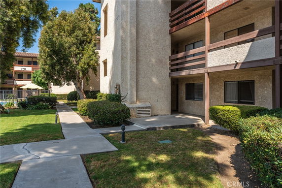 View of a multi-story building with balconies and surrounding pathways.
