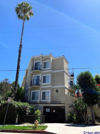 Front view of a multi-story residential building with balconies.