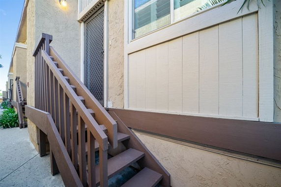 Front view of a building with an exterior staircase leading to a door.