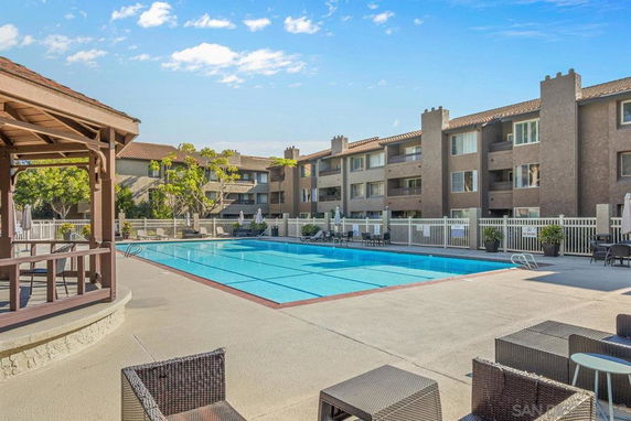 Outdoor swimming pool area with adjacent residential buildings.