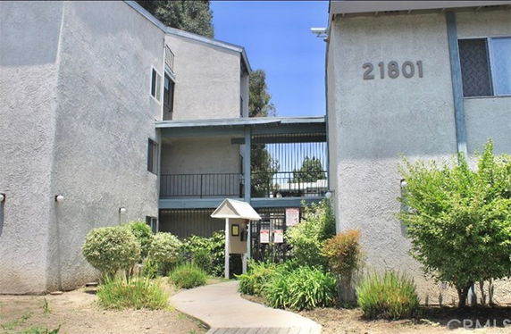 Front view of a multi-story building with a walkway leading to the entrance.