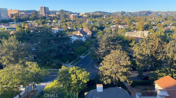 Panoramic view of a residential area with houses, trees, and surrounding landscape.