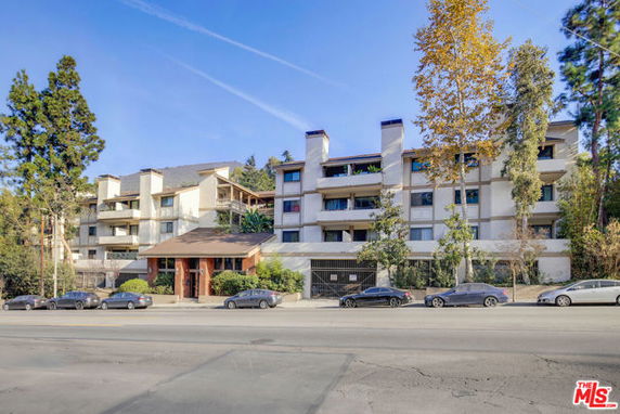 Front view of a multi-story apartment building with balconies.