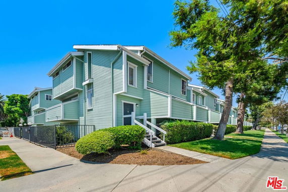 Front view of a multi-story residential building with green exterior siding.