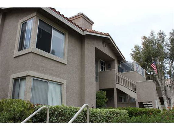 Front view of a two-story house with multiple windows and a balcony.