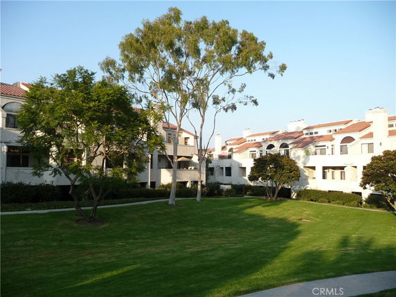 Front view of a multi-story residential building with a lawn area.