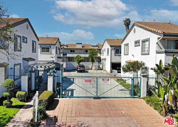 Front view of a gated residential complex with multiple two-story houses.