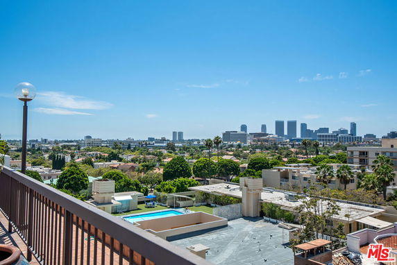 Panoramic view of a city skyline with buildings and greenery.