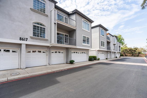 Front view of a multi-story townhouse with garages.