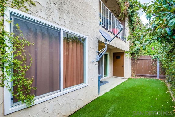 Exterior view of a building with a satellite dish and balcony.