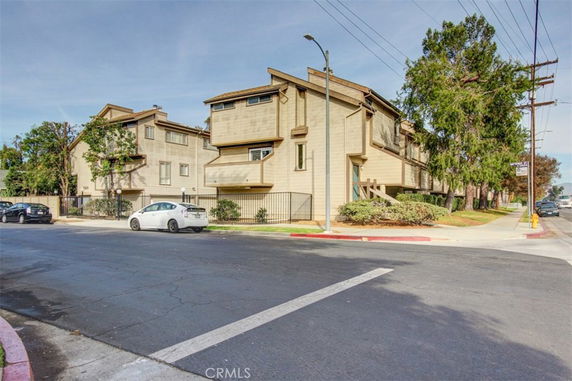 Front view of a modern multi-story apartment building with flat roofs and beige siding.