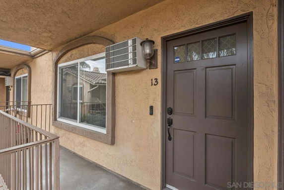 Exterior front view of a building entrance with a brown door and windows.