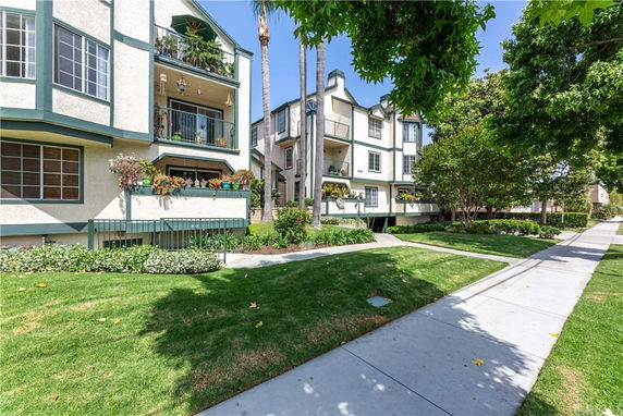 Front view of a multi-story residential building with balconies and landscaping.
