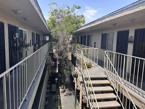 View of a two-story apartment complex with external walkways and railings.