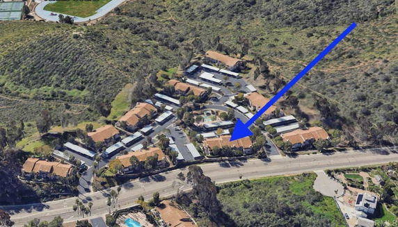 Aerial view of a residential community with roads and greenery.