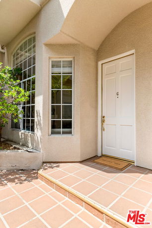 Front entryway of a house with a white door and large windows.