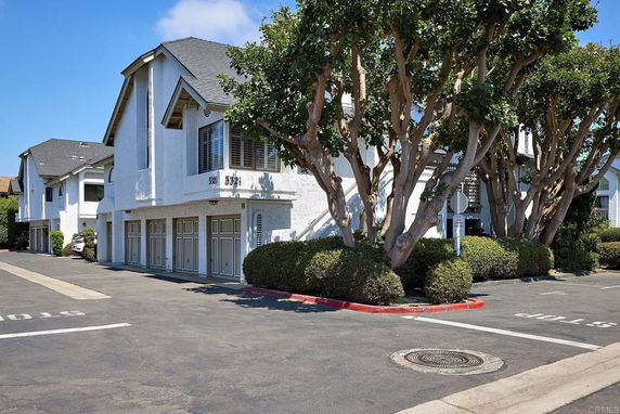 Front view of a two-story townhouse with garage doors.