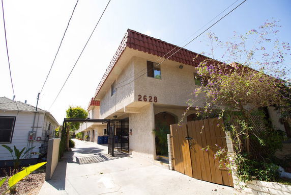 Front view of a two-story building with a red-tiled roof and the number 2628 on the facade.