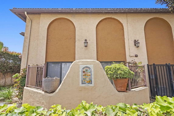 Front view of a two-story building with arched windows and decorative tile on the facade.