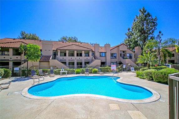 Residential building with a swimming pool in front.