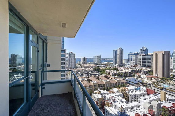 Panoramic view from a high-rise building balcony overlooking city skyline and waterfront.