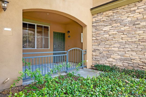 Front view of a house with an arched entrance and stone exterior.