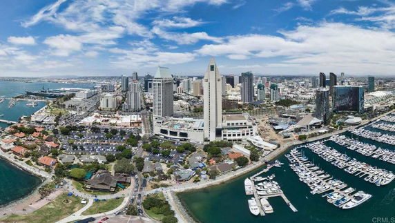 Panoramic view of a cityscape with a marina and high-rise buildings.