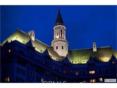 Night view of a building with illuminated green roofs and a prominent tower.
