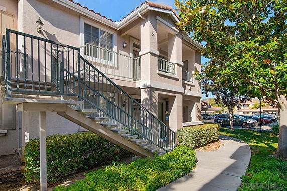 Front view of a two-story house with exterior stairs.