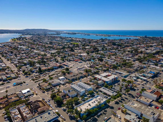 Aerial view of a coastal town with buildings and roads near the ocean.