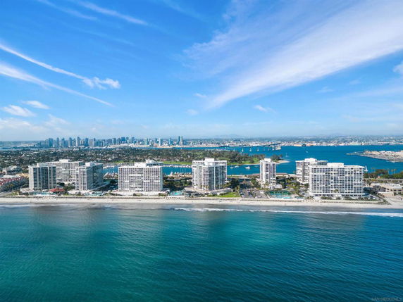 Wide view of beachfront high-rise buildings with a distant city skyline.
