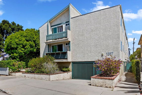 Front view of a multi-story residential building with balconies.