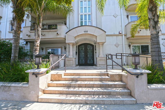 Front view of a multi-story building with a central entrance and stairway.