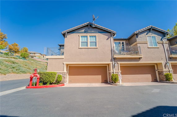 Front view of a two-story house with double garages and balconies.