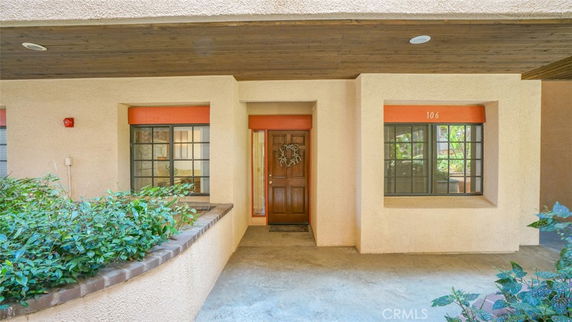 Front view of a building entrance with a decorative wreath on the door.