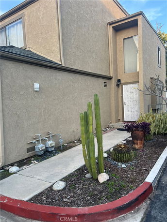 Front view of a two-story house with a simple pathway and plants.