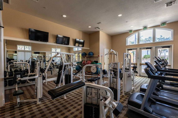 Indoor gym area with various exercise machines and equipment.