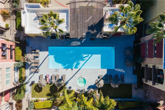 Aerial view of a swimming pool area with lounge chairs and umbrellas.